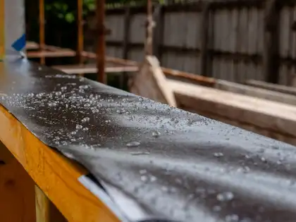 Regentropfen auf der schwarzen Fassadenbahn eines Holzrahmen-Wandelements